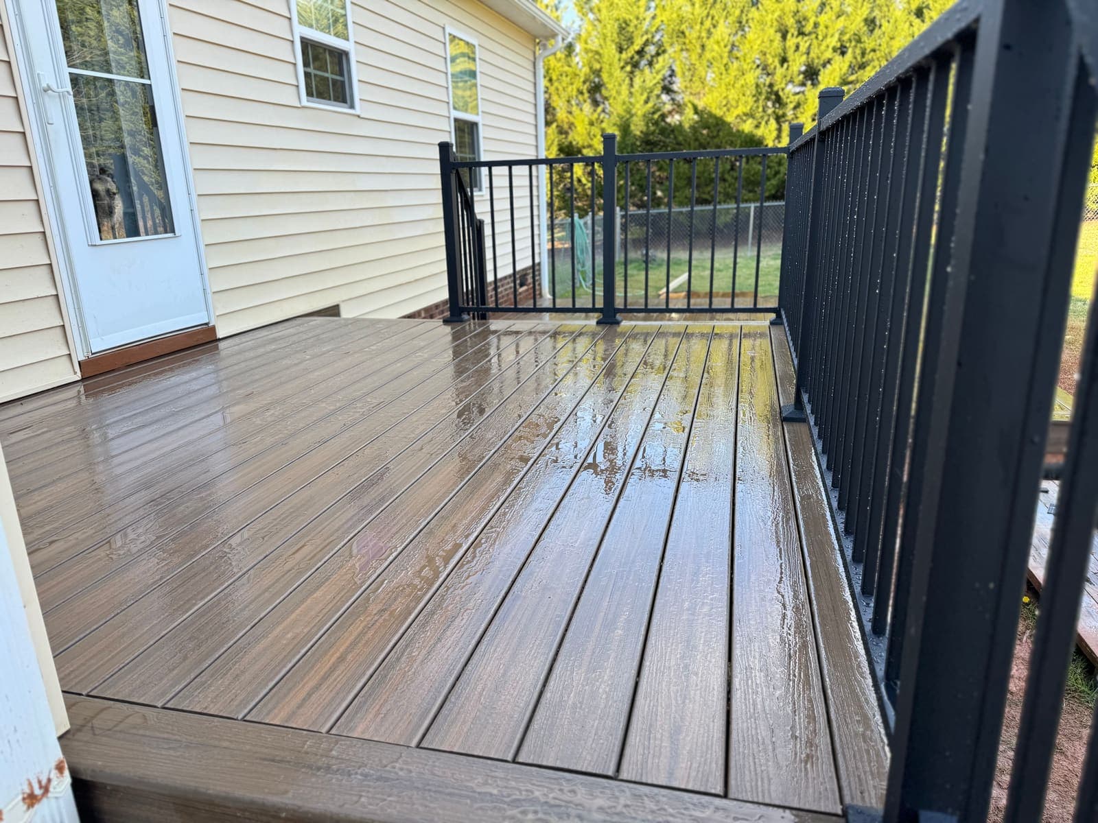 A well-maintained pressure-treated deck in a Rock Hill backyard surrounded by greenery.