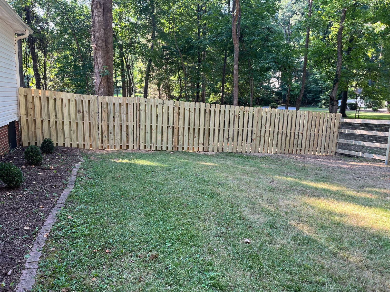 A well-maintained wooden fence marking a residential property line in Rock Hill, SC.