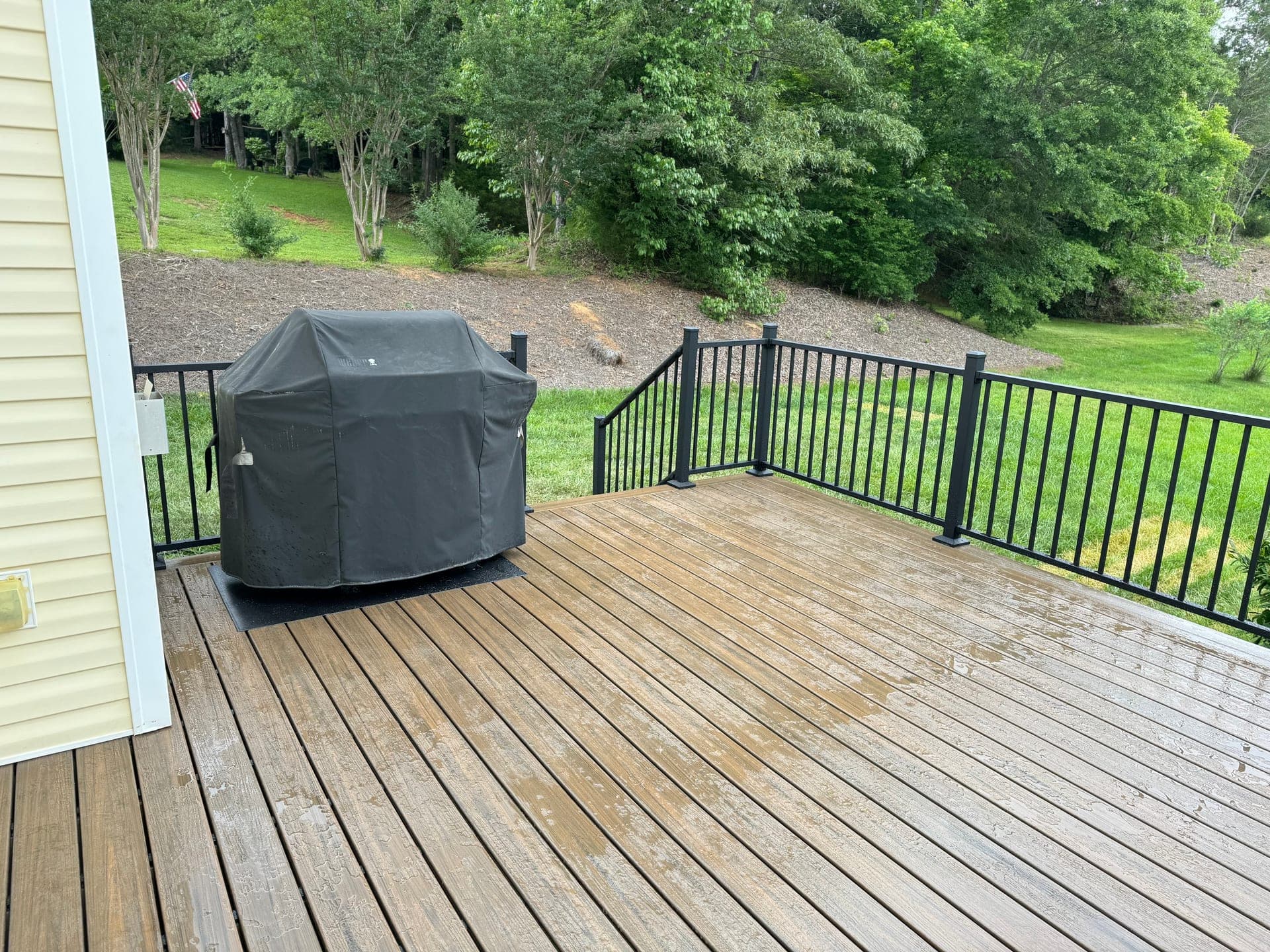 A sunny deck with rich brown stain surrounded by Carolina greenery